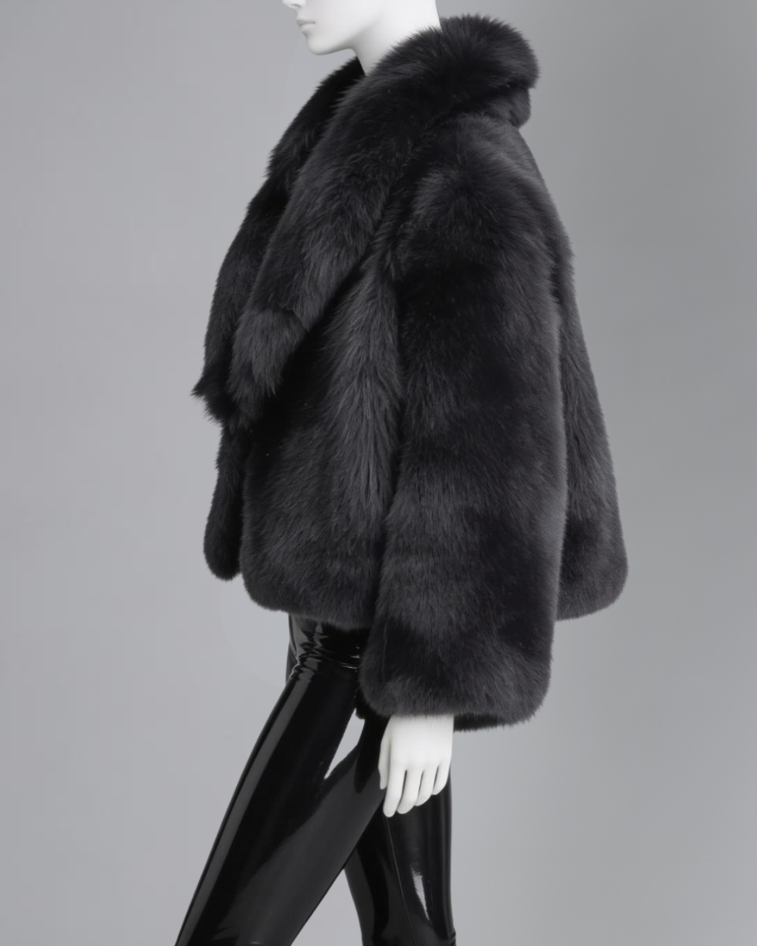 Black fur coat on a mannequin against a gray background